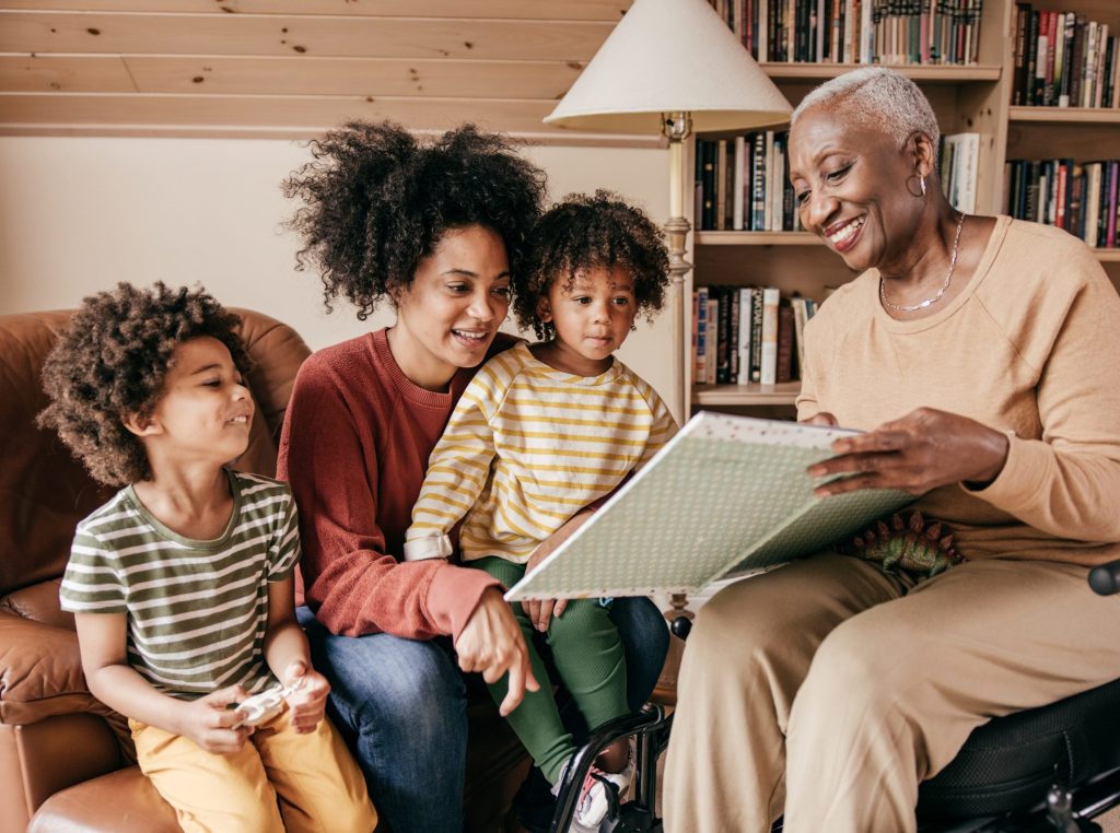 Grandma showing photo album to daughter and grandkids