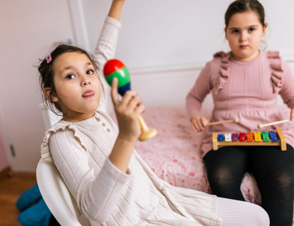 Two girls play with maracas