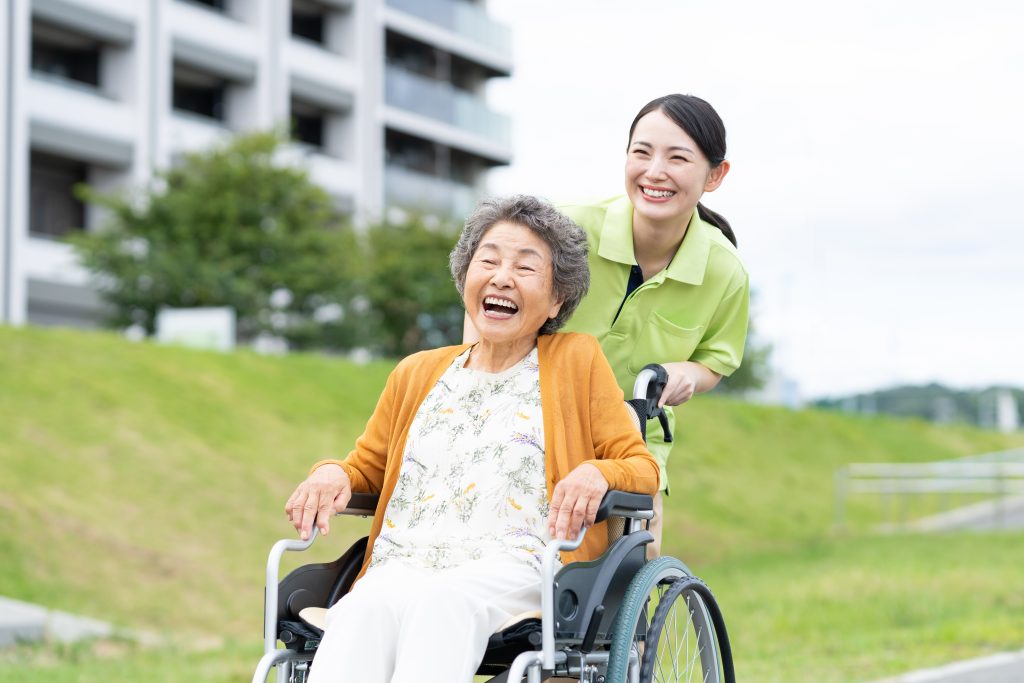 Daughter taking her mom in a wheelchair for an outside walk
